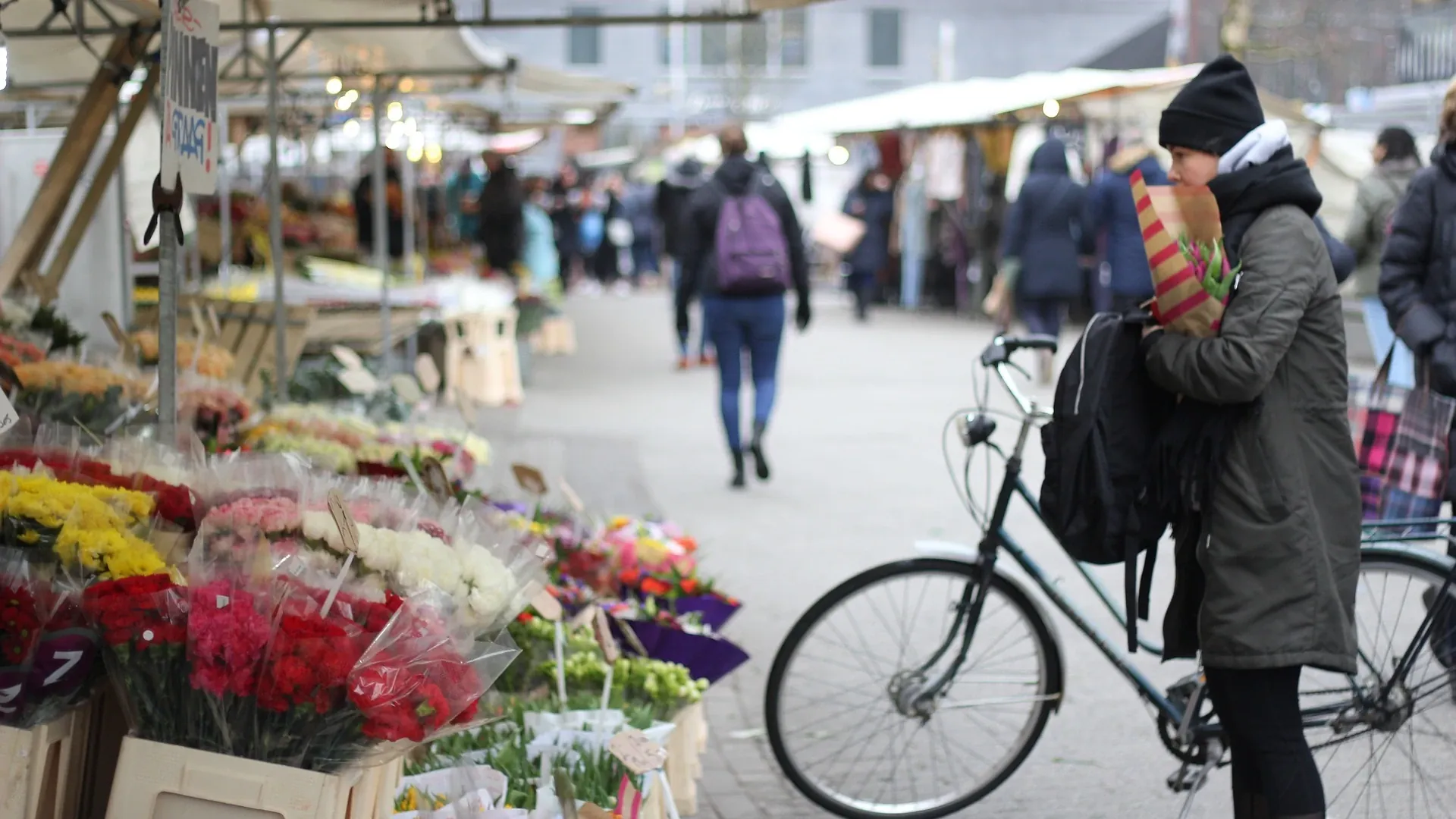 Una mujer compra tulipanes en un mercado de la ciudad