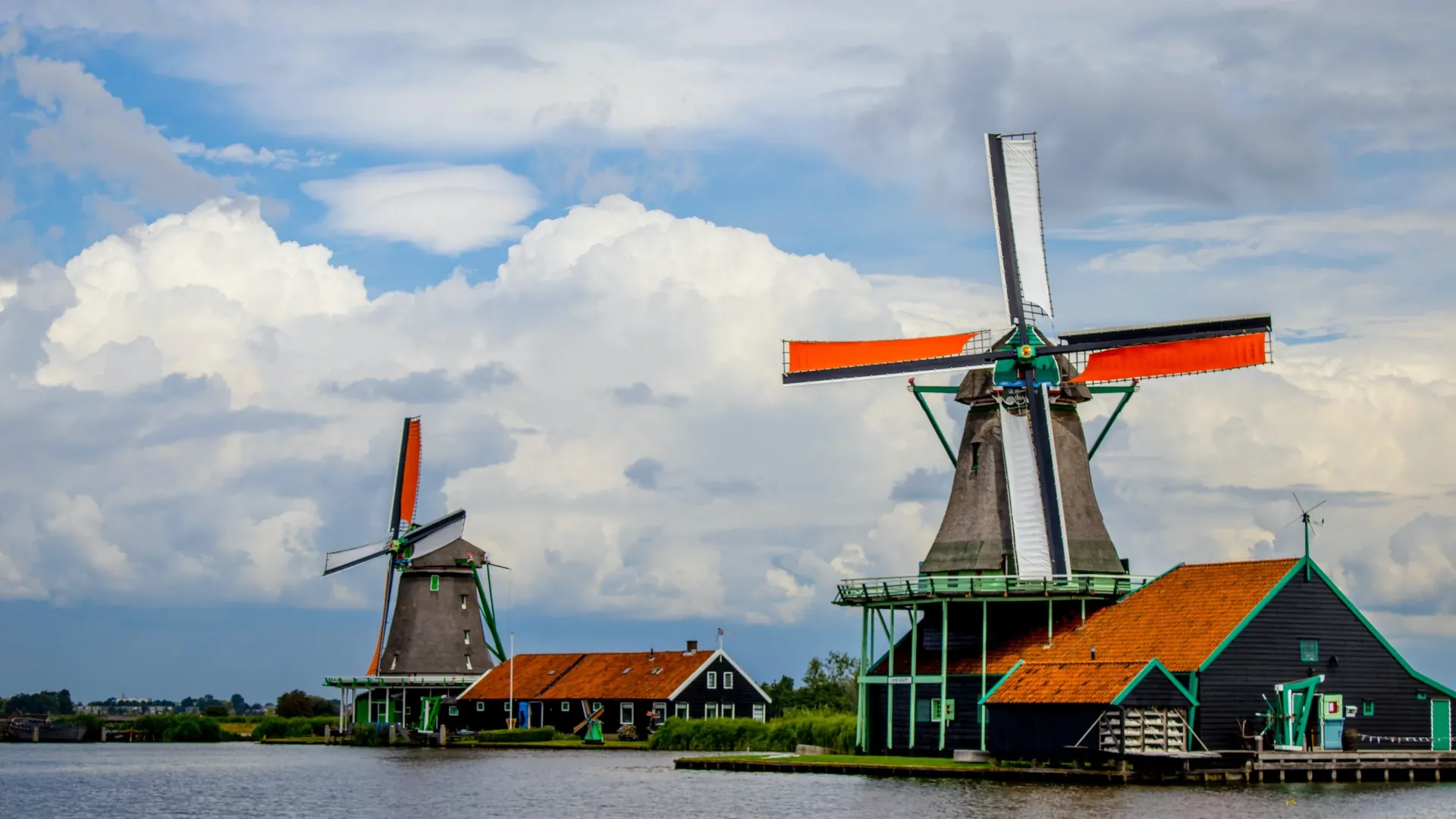 Two windmills on the banks of a canal in the city of Zaanse Schans